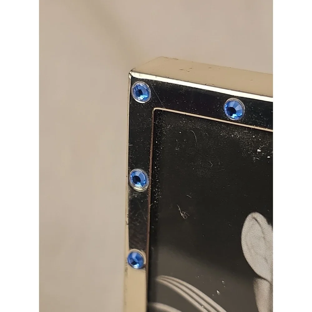 Mid-Century Hollywood Regency frame with polished metal and blue jewel insets.‎